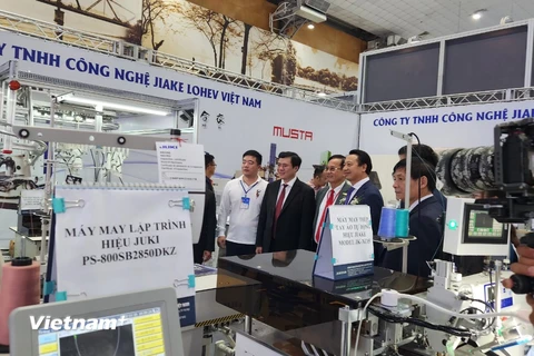 Thứ trưởng Nguyễn Sinh Nhật Tân cùng các đại biểu tham quan Triển lãm HanoiTex 2022. (Ảnh: Xuân Quảng/Vietnam+)