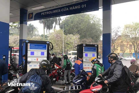 Người dân mua xăng tại cửa hàng của Petrolimex. (Ảnh: Đức Duy/Vietnam+)