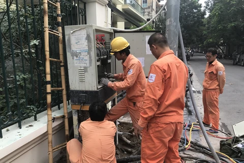 Nhân viên EVNHANOI kiểm tra vận hành thiết bị điện. (Ảnh: Xuân Quảng/Vietnam+)