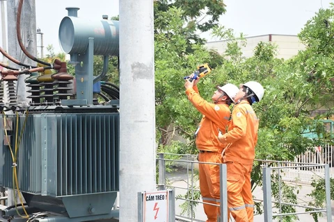 Nhân viên EVNHANOI kiểm tra tình trạng vận hành của thiết bị điện. (Ảnh: PV/Vietnam+)