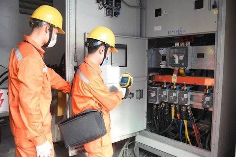 Nhân viên EVNHANOI kiểm tra vận hành thiết bị điện. (Ảnh: PV/Vietnam+)