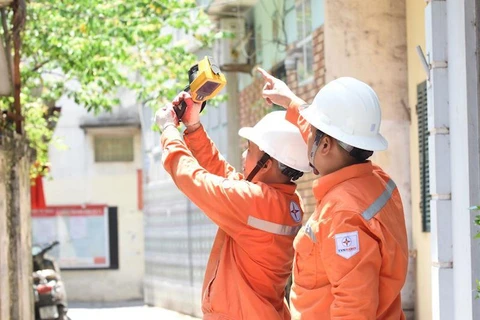 Nhân viên EVNHANOI kiểm tra các thiết bị điện, phòng tránh các sự cố. (Ảnh: PV/Vietnam+)