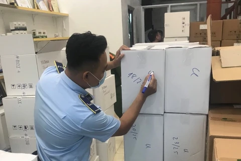 Lực lượng chức năng đang kiểm tra hàng hóa tại phường Kiến Hưng, quận Hà Đông, Hà Nội. (Ảnh: PV/Vietnam+)