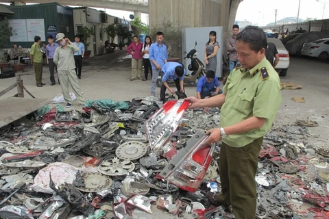 Lực lượng chức năng của Hà Nội tiêu hủy phụ tùng xe gắn máy vi phạm sở hữu trí tuệ. (Ảnh: Đức Duy/Vietnam+) 