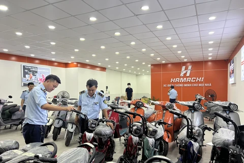 Lực lượng Quản lý Thị trường kiểm tra cơ sở kinh doanh xe điện. (Ảnh: PV/Vietnam+)