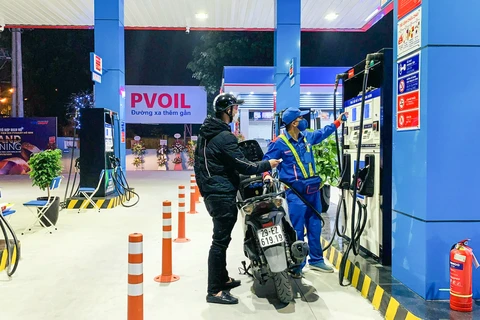 Người dân mua xăng tại cửa hàng thuộc PVOil. (Ảnh: PV/Vietnam+)