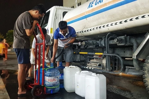 Người dân Khu Đô thị Thanh Hà lấy nước từ xe chở nước sạch. (Ảnh: Hoàng Hiếu/TTXVN)