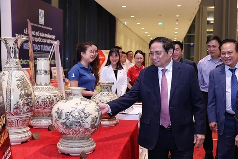 Thủ tướng Phạm Minh Chính thăm gian hàng trưng bày sản phẩm đạt Thương hiệu Quốc gia năm 2022. (Ảnh: TTXVN)