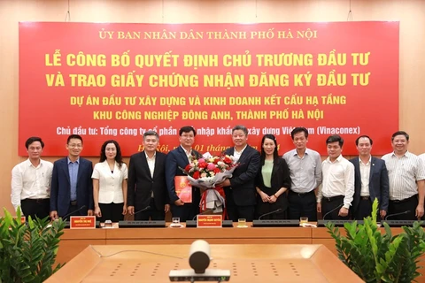 Phó Chủ tịch Ủy ban Nhân dân thành phố Hà Nội Nguyễn Mạnh Quyền cùng lãnh đạo các Sở, ngành tặng hoa chúc mừng Nhà đầu tư. (Ảnh: CTT Hà Nội) 