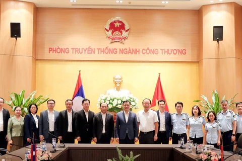 Thứ trưởng Bộ Công Thương Nguyễn Sinh Nhật Tân làm việc với Đoàn công tác của Bộ Công Thương Lào do Thứ trưởng Bountheung Douangsavanh làm Trưởng đoàn. (Ảnh: PV/Vietnam+)