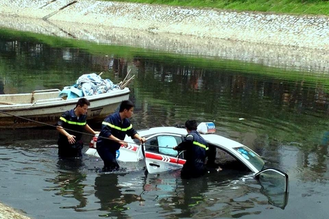 Chiếc taxi được trục vớt sau hơn 2 giờ chìm nghỉm dưới sông Tô Lịch. (Ảnh: Cộng tác viên)