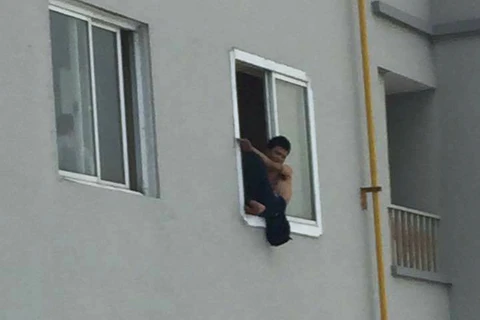 Nam thanh niên trèo lên cửa sổ, ném gạch đá xuống gây nguy hiểm cho cư dân tòa nhà Packexim. (Ảnh: otofun)