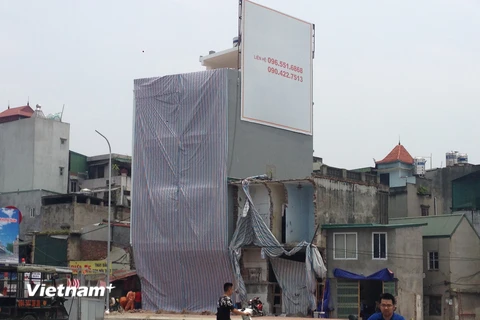 Tiến hành phá dỡ tại ngôi nhà lạ đời ôm cột điện (Ảnh: Sơn Bách/Vietnam+)