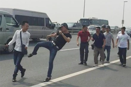 Phóng viên Quang T (áo trắng) bị một nhóm người hành hung khi đang tác nghiệp tại cầu Nhật Tân. (Ảnh: MC)
