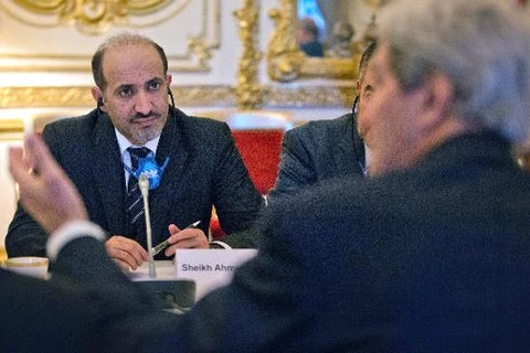 Chủ tịch SNC Ahmad al-Jarba (trái) nghe Ngoại trưởng Mỹ John Kerry (phải) phát biểu trong một cuộc họp ngày 13/1. (Nguồn: AFP)