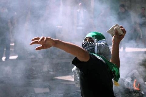 Một thanh niên Palestine ném đá về phía binh sỹ Israel vào ngày 27/9/2013. (Nguồn: AFP)