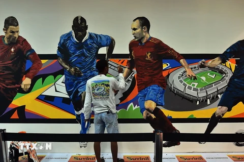 Các họa sỹ trang trí bức tường tại sân bay Congonhas ở thành phố Sao Paulo, Brazil, chào đón vòng chung kết World Cup 2014. (Nguồn: AFP/TTXVN)