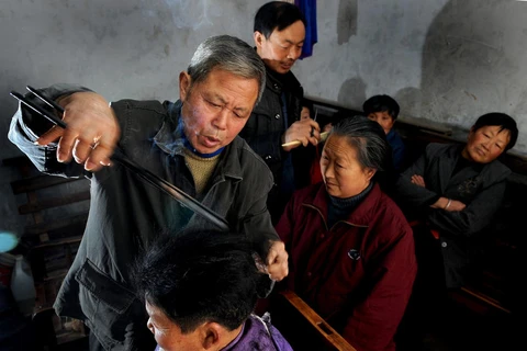 [Photo] Tiệm cắt tóc bằng kẹp sắt nung độc đáo của ông lão Trung Quốc