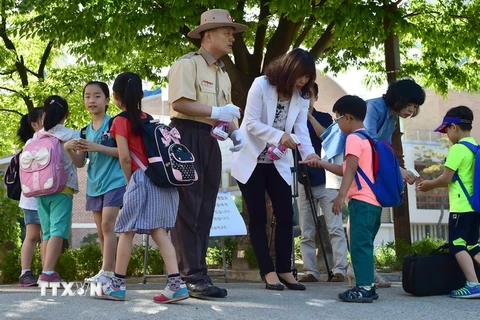Học sinh một trường tiểu học ở Seoul được làm vệ sinh nhằm hỗ trợ khả năng chống virus MERS ngày 3/6. (Nguồn: AFP/TTXVN)