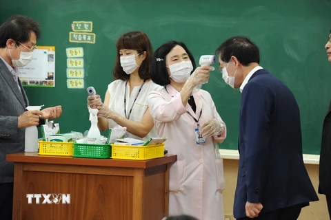 Kiểm tra thân nhiệt cho người dân để phòng tránh lây nhiễm MERS ở thủ đô Seoul ngày 17/6. (Nguồn: THX/TTXVN)