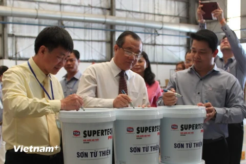 Ông Huỳnh Văn Tý, Thứ trưởng Bộ Lao động Thương binh-Xã hội, ký tên trên sản phẩm đầu tiên của chiến dịch này. (Ảnh: Hà Huy Hiệp/Vietnam+)