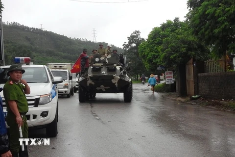 Xe thiết giáp đưa dân khỏi vùng ngập lụt tại Uông Bí, Quảng Binh. (Ảnh: Nguyễn Hoàng/TTXVN)