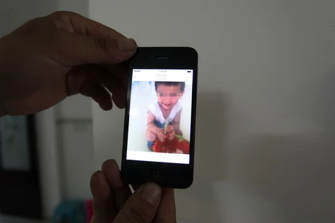 Hình ảnh cậu bé trong điện thoại của người cha. (Nguồn: QQ)
