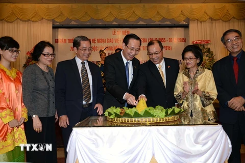 Phó Chủ tịch Ủy ban Nhân dân Thành phố Hồ Chí Minh Lê Thanh Liêm và Tổng lãnh sự Indonesia Jean Anes cắt bánh truyền thống của Indonesia tại Lễ kỷ niệm. (Ảnh: Thanh Vũ/TTXVN)