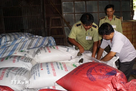 Lực lượng quản lý thị trường kiểm tra số đường cát trắng nhập lậu tại kho hàng ở Tây Ninh. (Ảnh: Thanh Tân/TTXVN)