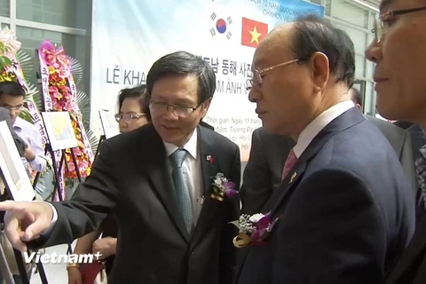 Đại sứ Phạm Hữu Chí giới thiệu cho các đại biểu Hàn Quốc tham quan triển lãm. (Ảnh: Phạm Duy/Vietnam+)
