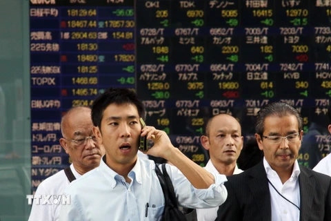 Nhà đầu tư theo dõi tỷ giá chứng khoán tại thủ đô Tokyo, Nhật Bản. (Nguồn: AFP/TTXVN) 