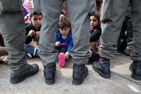 Trẻ em tỵ nạn ngồi đợi cùng người thân ở biên giới Áo-Hungary ngày 20/9. (Nguồn: AFP)