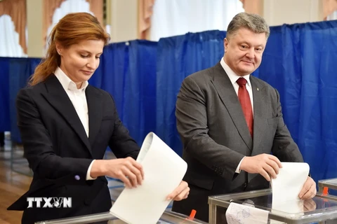 Tổng thống Ukraine Petro Poroshenko (phải) và phu nhân bỏ phiếu tại một địa điểm bầu cử ở Kiev. (Nguồn: AFP/TTXVN)