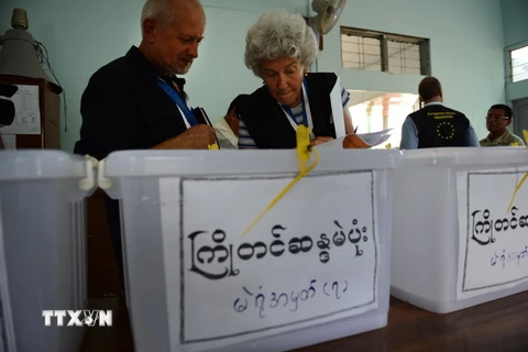 Các quan sát viên thuộc ​EU kiểm tra hòm phiếu tại một điểm bầu cử ở Yangon, Myanmar ngày 30/10. (Nguồn: AFP/TTXVN)