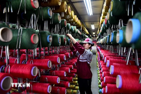 Công nhân làm việc tại một nhà máy dệt thảm ở tỉnh Sơn Đông, miền Đông Trung Quốc ngày 26/4. (Nguồn: THX/TTXVN)