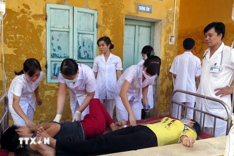 Các y, bác sỹ bệnh viện Trực Ninh khẩn trương khám cho công nhân bị ngộ độc. (Ảnh: Văn Đạt/TTXVN)