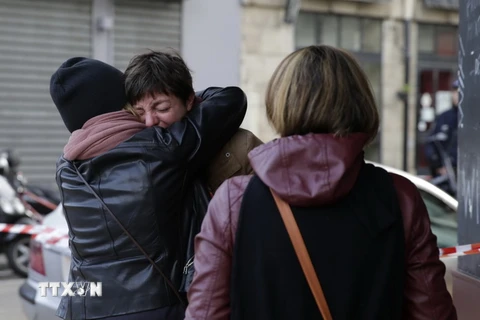 Nỗi đau mất mát người thân tại hiện trường vụ tấn công khủng bố ở nhà hàng Carillon, quận số 10, thủ đô Paris, ngày 14/11. (Nguồn: AFP/TTXVN)