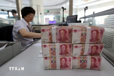 Kiểm tiền nhân dân tệ tại ngân hàng ở Liên Vận Cảng, tỉnh Giang Tô, miền Đông Trung Quốc ngày 11/8. (Nguồn: AFP/TTXVN)