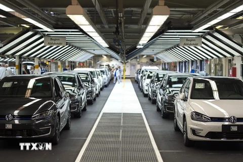 Công nhân lắp ráp kiểm tra sản phẩm tại dây chuyền sản xuất xe VW tại nhà máy ở Wolfsburg, miền trung Đức ngày 21/10. (Nguồn: AFP/TTXVN)