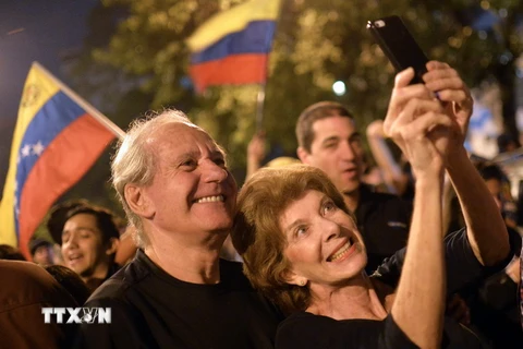 Những người ủng hộ Liên minh đối lập mừng chiến thắng tại thủ đô Caracas, sau khi công bố kết quả. (Nguồn: AFP/TTXVN)