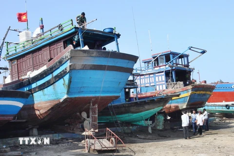 Ngư dân Quảng Trị sửa chữa tàu thuyền chuẩn bị cho mùa đánh bắt cá. (Ảnh: Hồ Cầu/TTXVN)