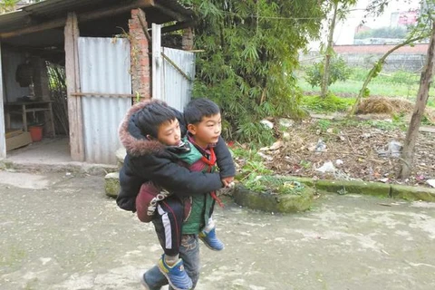Hai cậu bé cõng nhau đến trường. (Nguồn: QQ)
