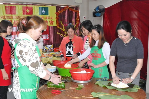 Phó Tổng Lãnh sự Vũ Chi Mai (ngoài cùng bên phải) gói bánh chưng cùng bà con lao động tại Macau. (Ảnh: Vietnam+)