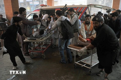 Nhân viên tình nguyện và an ninh chuyển nạn nhân bị thương trong vụ nổ tới bệnh viện ở Peshawar. (Nguồn: AFP/TTXVN)