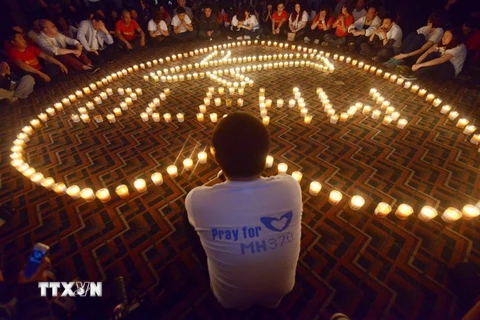 Thân nhân các hành khách trên chuyến bay MH370 cầu nguyện cho người thân tại Bắc Kinh ngày 8/4/2014. (Nguồn: AFP/TTXVN)