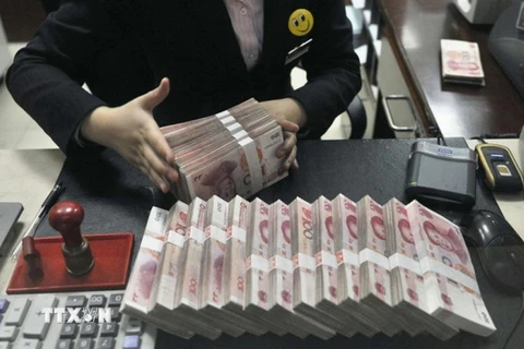 Kiểm đồng nhân dân tệ tại một điểm giao dịch ngoại hối ở Thượng Hải, Trung Quốc. (Nguồn: Reuter/TTXVN)
