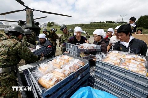 Lực lượng cứu hộ Nhật Bản chuyển lương thực, nước uống để phân phát cho người dân sau trận động đất ở Minami-Aso, Kumamoto ngày 17/4. (Nguồn: AFP/TTXVN)