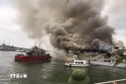 Lực lượng Cảnh sát phòng cháy chữa cháy Quảng Ninh khẩn trương phun nước dập đám cháy lớn đang bùng phát dữ dội trên tàu du lịch QN 6299. (Nguồn: TTXVN​)