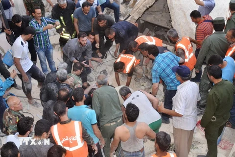 Tìm kiếm người sống sót sau một vụ pháo kích ở Syria. (Nguồn: AFP/TTXVN)