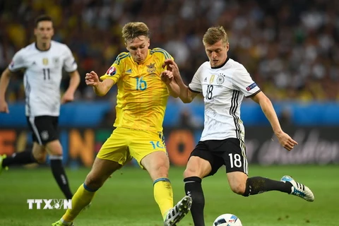Trung vệ Toni Kroos (phải) đội tuyển Đức tranh bóng với trung vệ Serhiy Sydorchuk của đội tuyển Ukraine. (Nguồn: AFP/TTXVN)